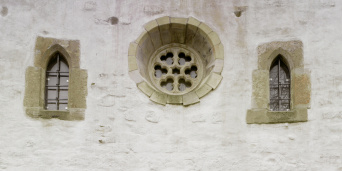 Detail of the facade. A large rose window is flanked by two smaller lancet windows.