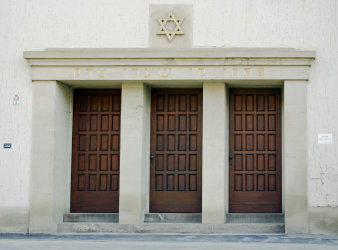 Three wooden doors in a row, lined with pillars, above the Star of David