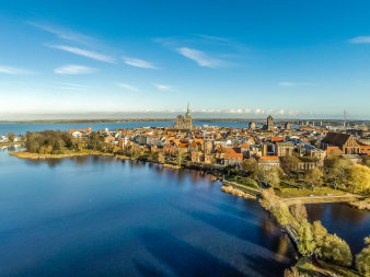 Das Foto zeigt die Altstadtinsel von Stralsund im Sonnenschein, aus der Luft aufgenommen.