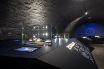 Ausstellungstisch mit archäologischen Fundstücken in einer Glasvitrine