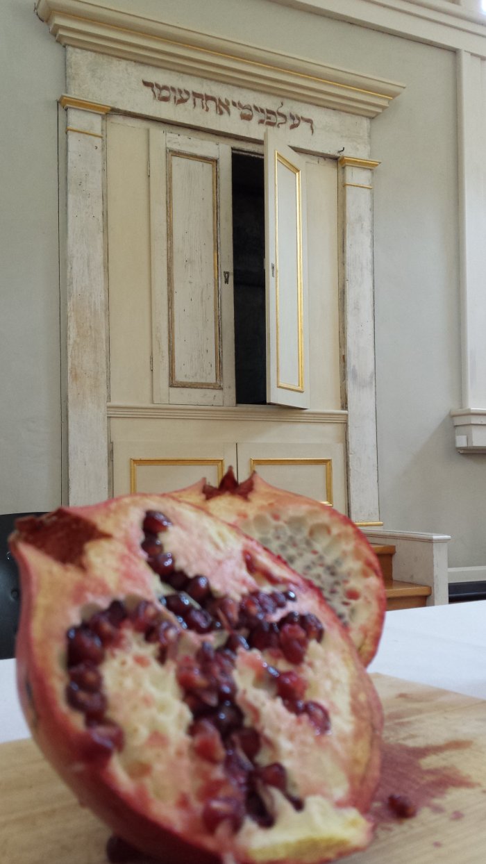 Workshop "Alles koscher! oder: Hat der Granatapfel wirklich 613 Kerne?" Ein halbierter Granatapfel liegt auf einem Tisch im Betsaal der Begegnungsstätte Kleine Synagoge.