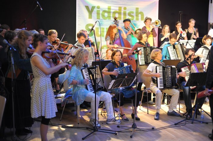 Yiddish Summer Weimar goes Erfurt 2017 – Caravan Orchestra Abgebildet sind junge und ältere Muiker des Caracan Orchestras aus Haifa. Alle Musikerinnen und Musiker halten ein Instrument in den Händen und spielen darauf.