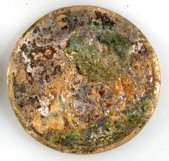eine runde Metallscheibe, auf der ein verblichenes Bild von einem Fuchs zu sehen ist, der auf einen Raben schaut