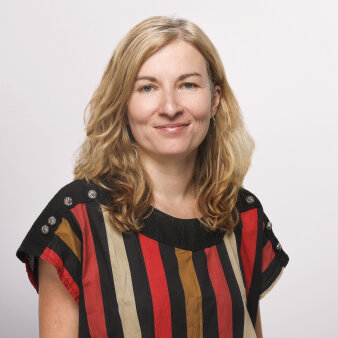 Foto: Dr. Franziska Krah © Jüdisches Museum Frankfurt Frau mittleren Alters mit Rot-Schwarz-Braun gestreiftem Oberteil und blonden langen Haaren