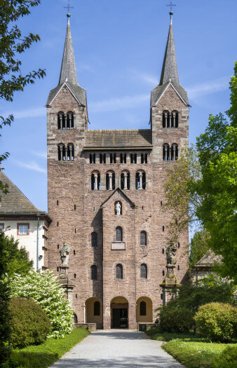 Eine Kirche mit zwei hohen Türmen umgeben von viel grüner Natur