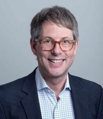 Portrait eines Mannes mit Brille und blauem Anzug