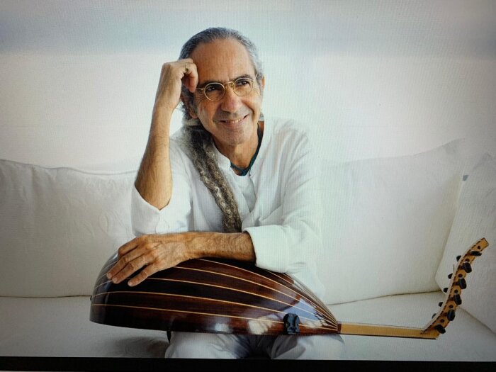 Yair Dalal Jüdischer Musiker mit seinem Instrument Oud auf einem weißen Sofa sitzend