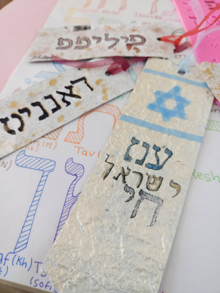 Selbst gestaltete Lesezeichen aus buntem Papier mit Schriften und Zeichen
