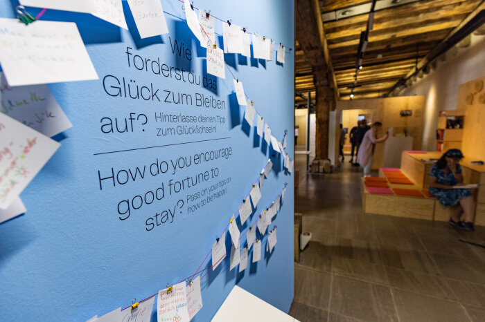 Interaktive Station in einer Ausstellung mit mehreren Personen im Hintergrund