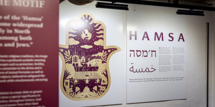 Schautafeln in einer Ausstellung mit Schriftzug und Bildmotiv in Rottönen