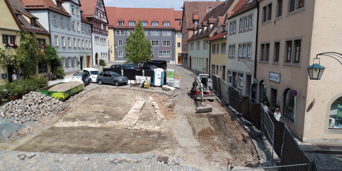 Ausgrabungsstätte mit Bagger inmitten von Wohnhäusern