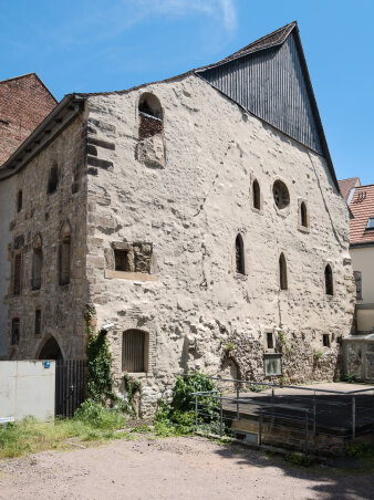 Steinernes Gebäude au dem Mittelalter mit spitzem Dach und verschiedenen Fenstern