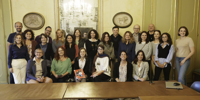 Gruppenfoto mit mehreren Personen in einem Raum mit goldverzierten Wänden