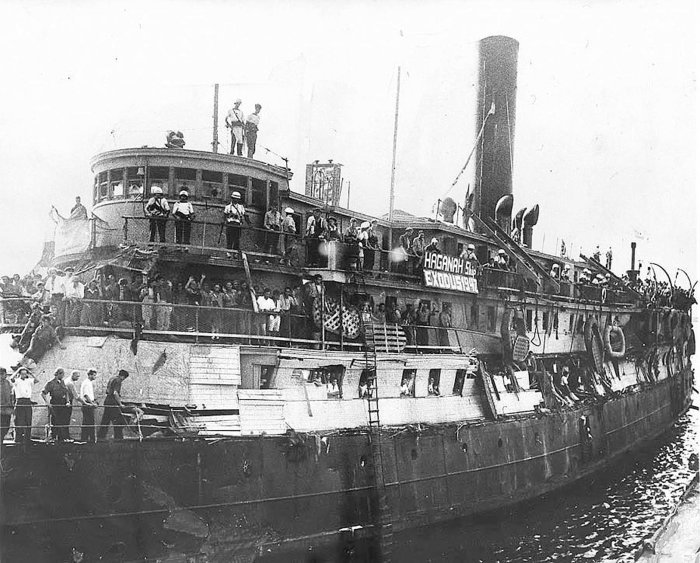 Eine Schwarz-Weiß Aufnahme des Schiffes "Exodus" bei seiner Ankunft in Haifa. Viele Menschen stehen an Bord.