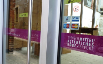 Pinke Bauchbinde an der Alten Synagoge wirbt für den Welterbe-Antrag