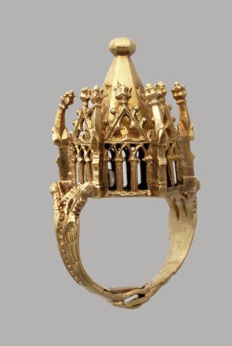ein goldener Ring mit aufwändig verziertem Aufbau