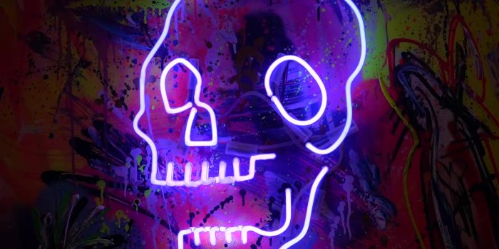 Foto: Aus der Ausstellung „Aggroschaft – Marc Jung & the Gang“ © Stadtverwaltung Erfurt Ein leuchtender Totenkopf vor gespraytem Hintergrund