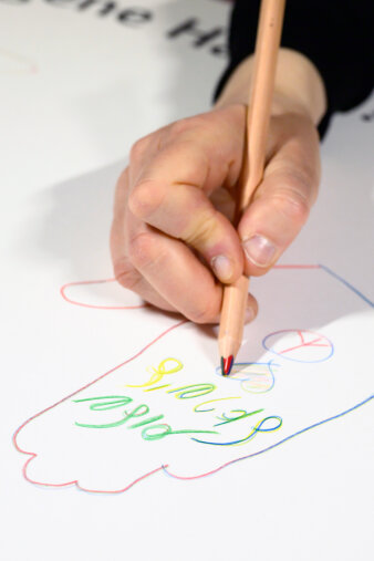 eine Hand zeichnet mit Buntstift eine Hand