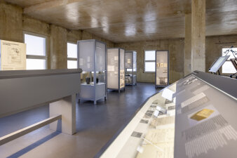 Ausstellungsraum mit industriellem Ambiente und verschiedenen Schautafeln und Installationen